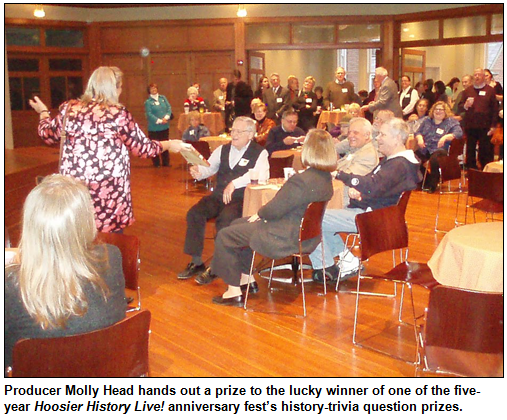 Producer Molly Head hands out a prize to the lucky winner of one of the five-year Hoosier History Live! anniversary fest’s history-trivia question prizes. Photo by Bill Holmes.